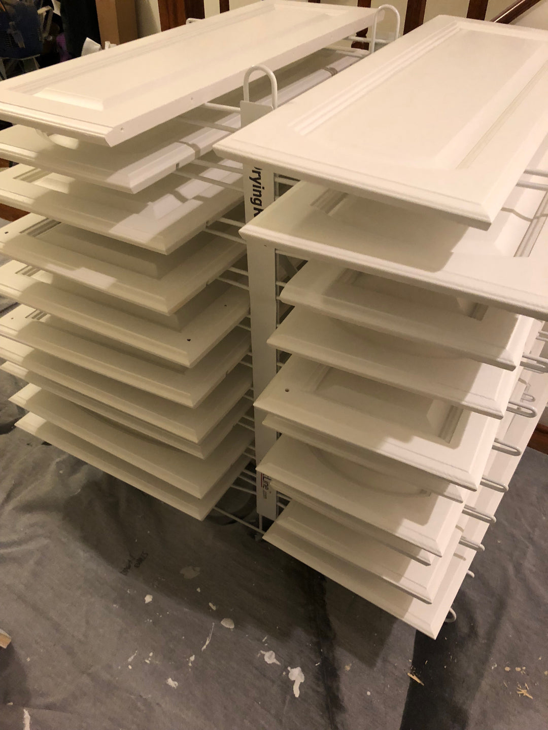 PRODRYINGRACK TT (PDRTT) IN USE ON FLOOR WITH WHITE CABINET DOORS DRYING ON RACK