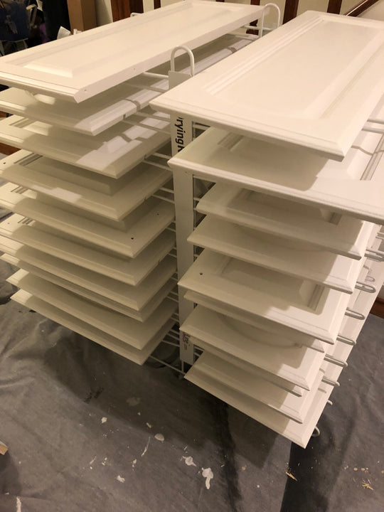 PRODRYINGRACK TT (PDRTT) IN USE ON FLOOR WITH WHITE CABINET DOORS DRYING ON RACK