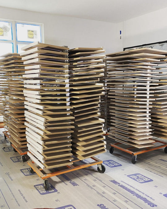 Multiple PaintLine 50-shelf drying racks filled with brown pieces of wood for storage and organization