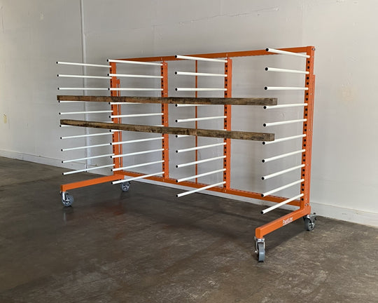 Orange metal rack with 4 towers and 10 levels of white shelves, holding two pieces of plywood