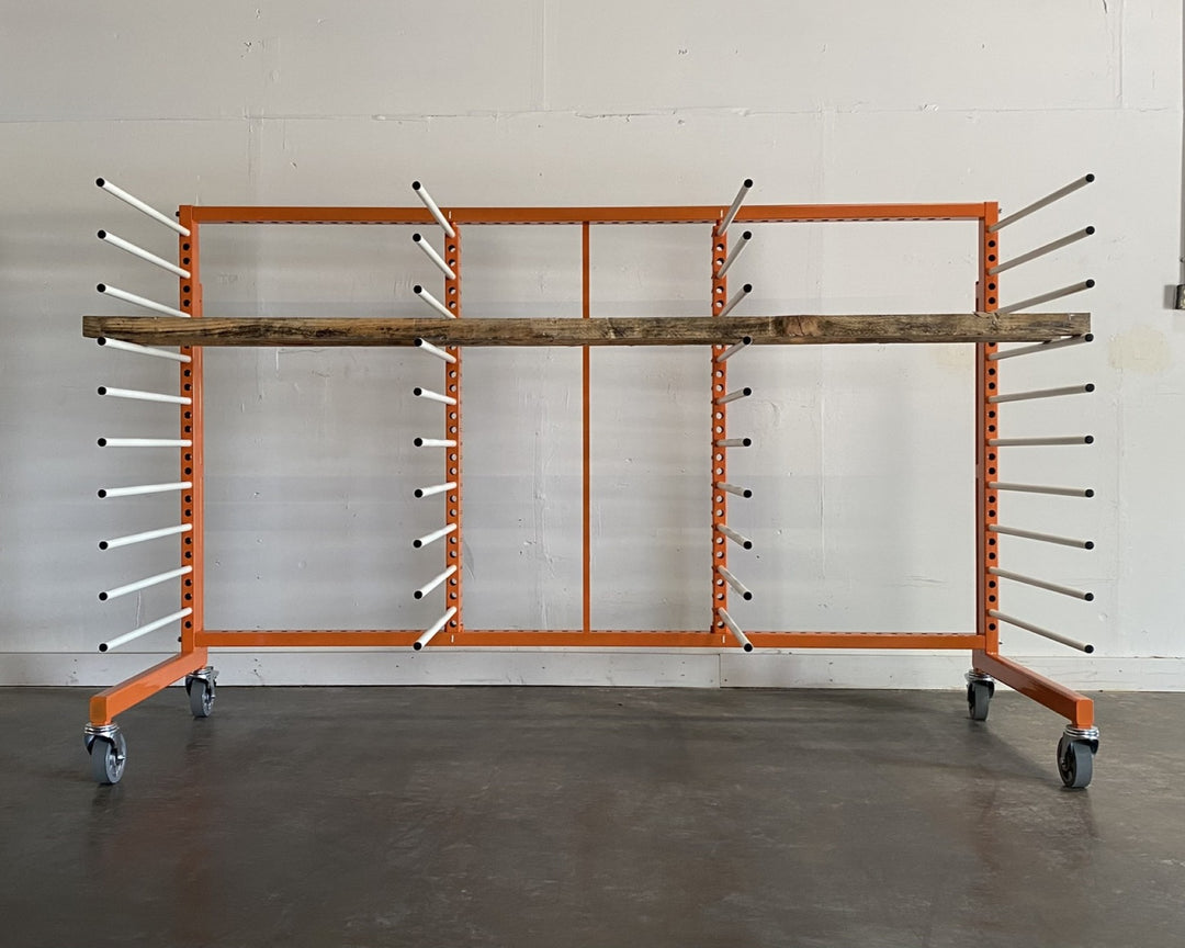 Orange metal rack with 4 towers and 10 levels of white shelves, holding a piece of long plywood