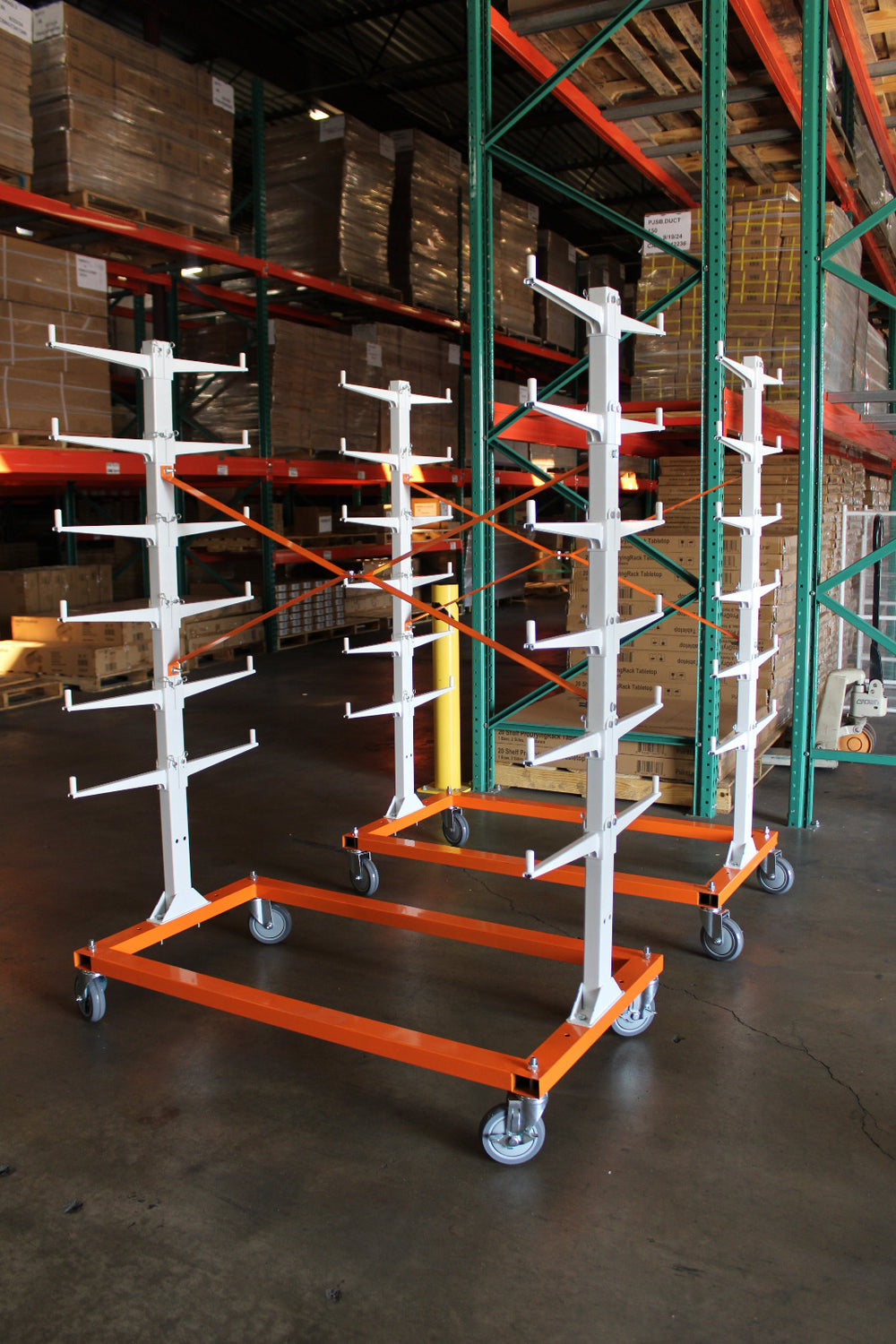 Two orange and white trim carts with wheels in a warehouse setting