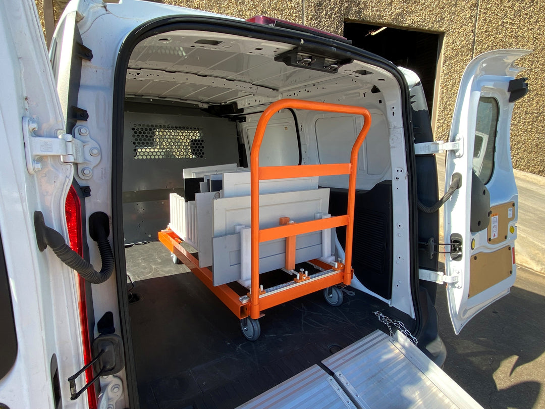Van interior with an orange transport rack filled with white cabinet doors for storage