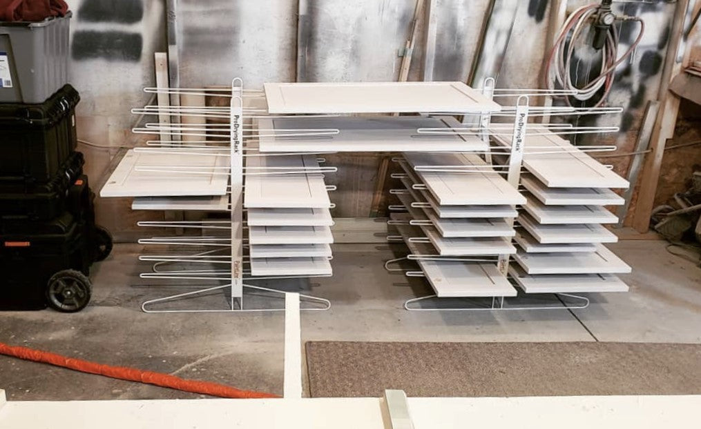 2 PRODRYINGRACK TT (PDRTT) IN USE ON FLOOR WITH WHITE CABINET DOORS DRYING ON RACK