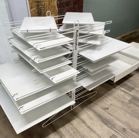 White cabinet doors organized on a 20-shelf drying rack sitting on the floor