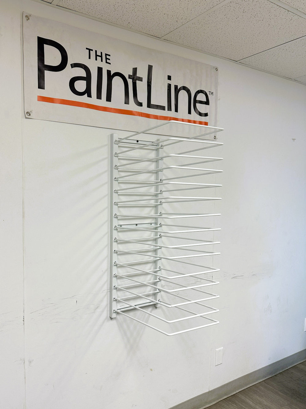 PRODRYINGRACK WALL MOUNT (PDRWM) MOUNTED ON WALL WITH PAINTLINE BANNER