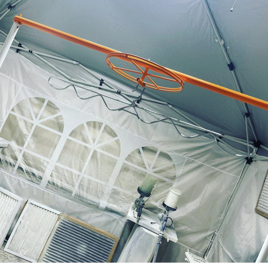 Ceiling view of a tent with a PSDR Spinner and metal hanger used for spraying cabinet doors
