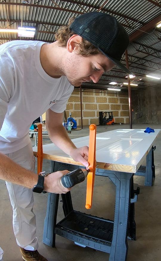 INTERIOR DOOR SPRAY AND DRY SERIES (PSDRID) ORANGE PLASTIC BASE SUPPORTS BEING SCREWED ONTO BOTTOM OF INTERIOR DOOR