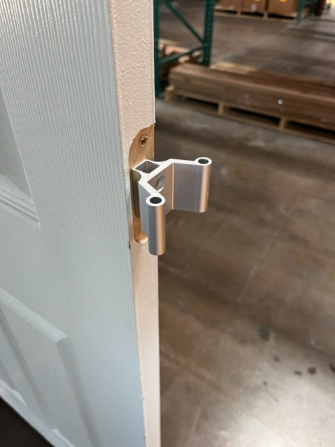 Closeup of the metal VClips attached to the hinge pocket of an interior door