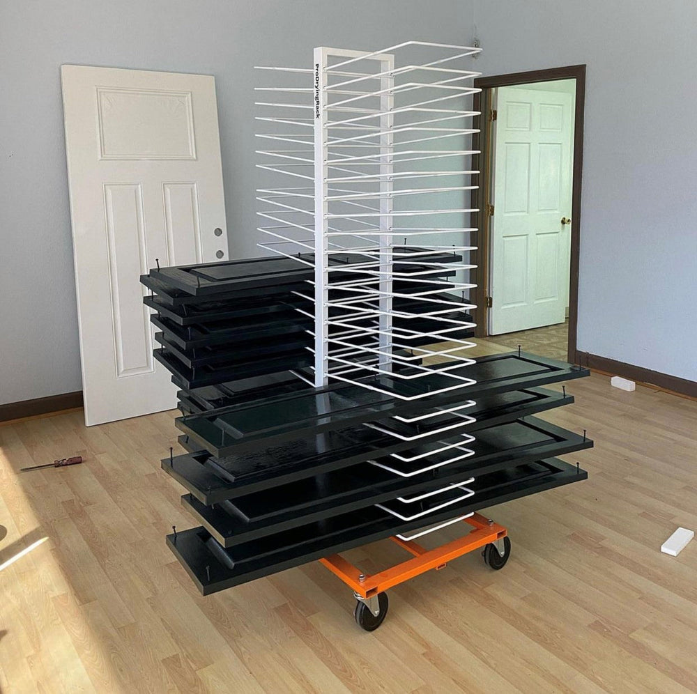50-Shelf White and Orange cabinet door drying rack, half full with black cabinet doors