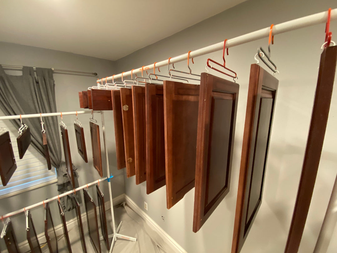 Brown cabinet doors hanging on metal drying racks