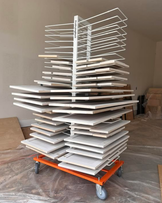 White cabinet doors drying on a PaintLine 50-shelf mobile drying rack