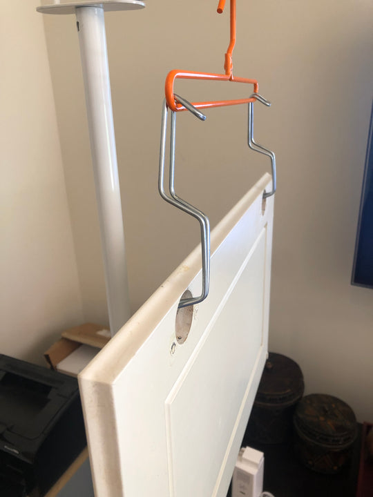 PRODRYINGRACK SD (PSDR) SERIES EFC HINGE HOOKS IN USE ON STANDARD HANGER WITH WHITE CABINET DOOR HUNG BY HINGE POCKET